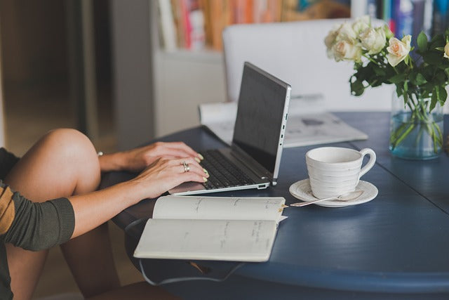 professional translator working working on a computer with coffee and note pad